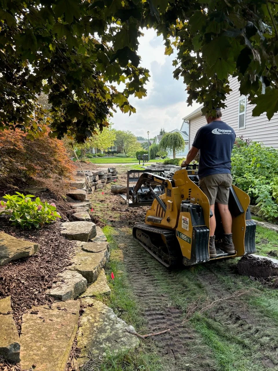 Professional hardscape crew with tools and equipment ready for paver and retaining wall installation projects.