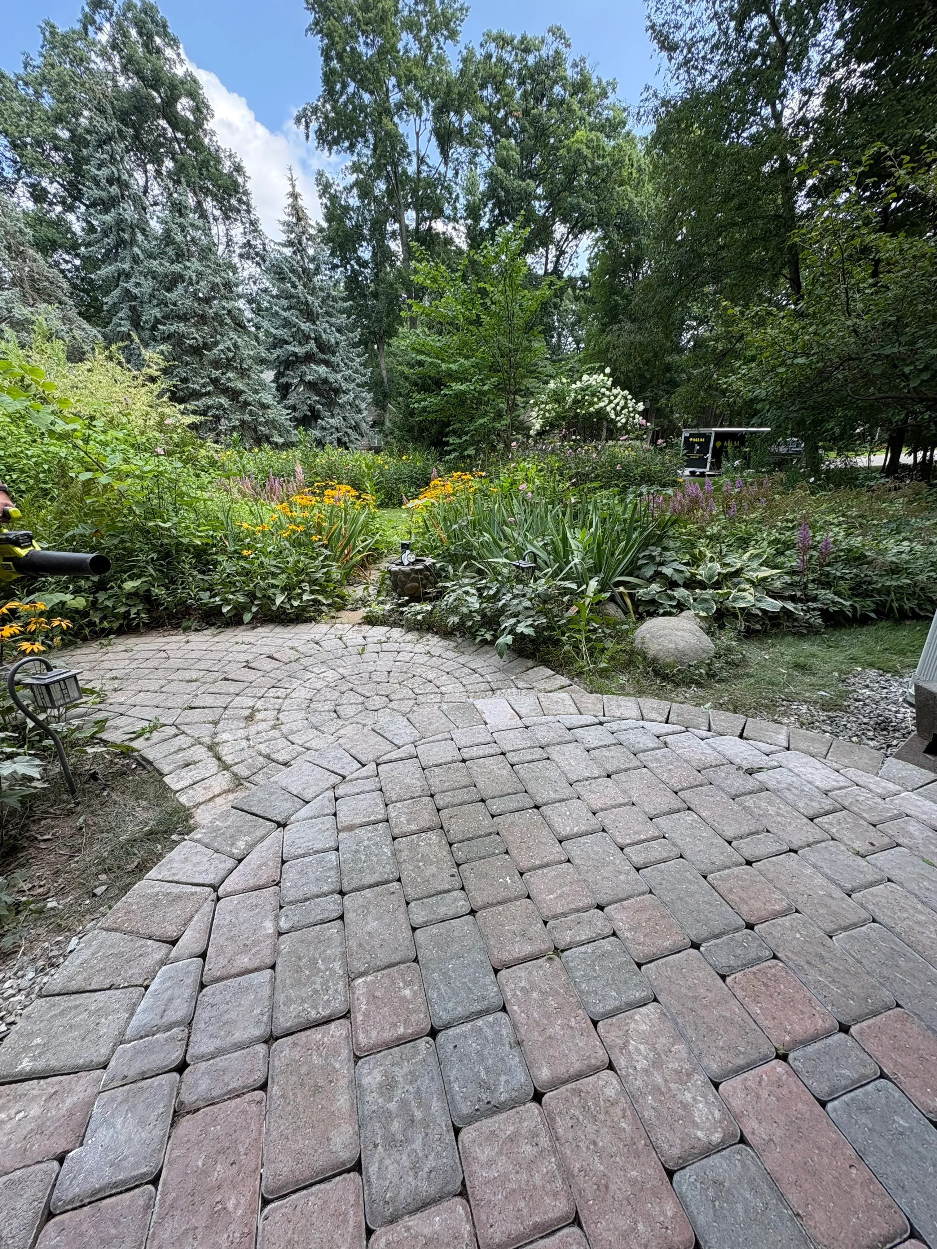 Charcoal and burgundy permeable concrete pavers installed in running bond pattern on residential driveway