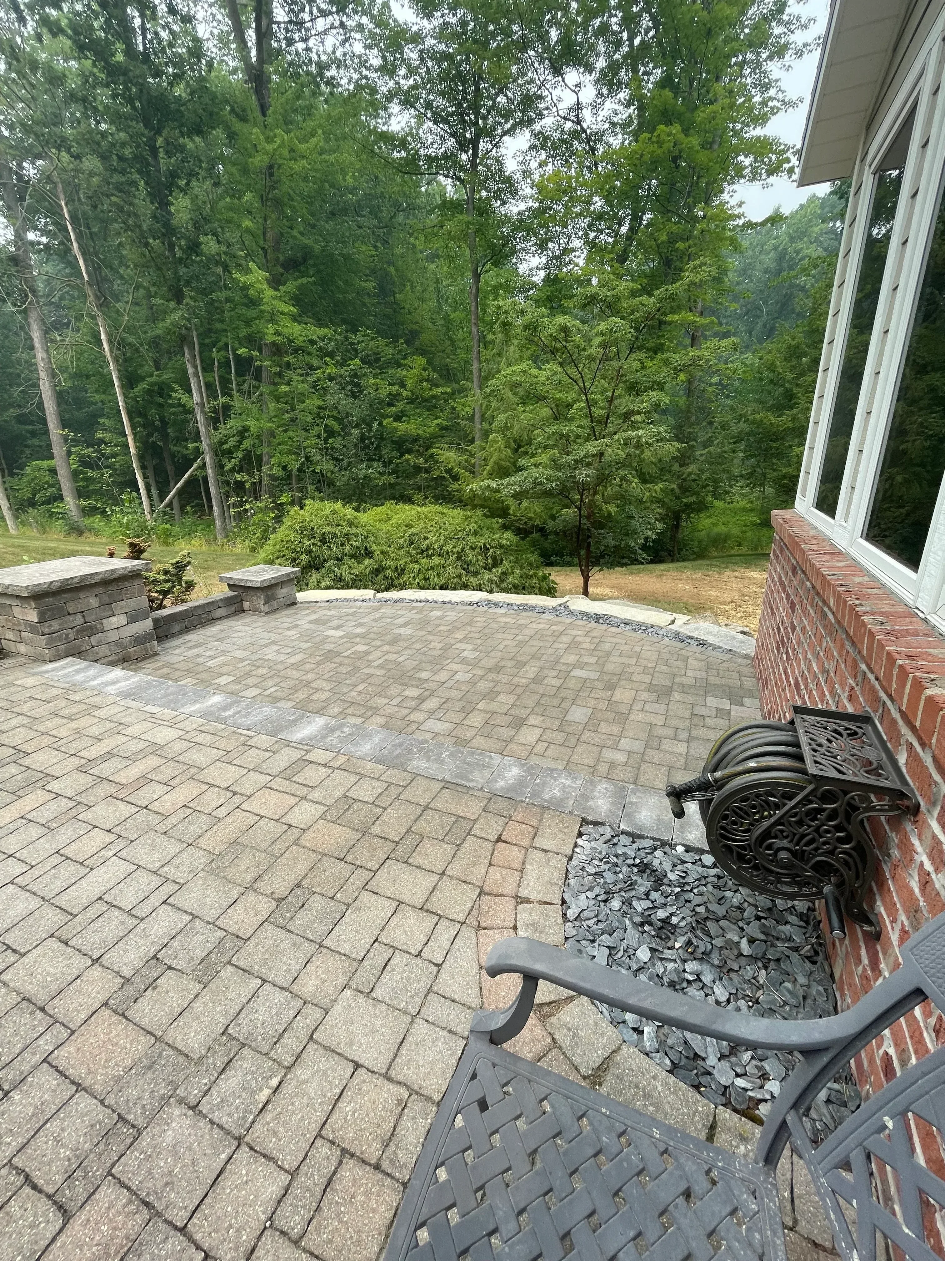 Brick paver patio with geometric pattern and metal edging installation