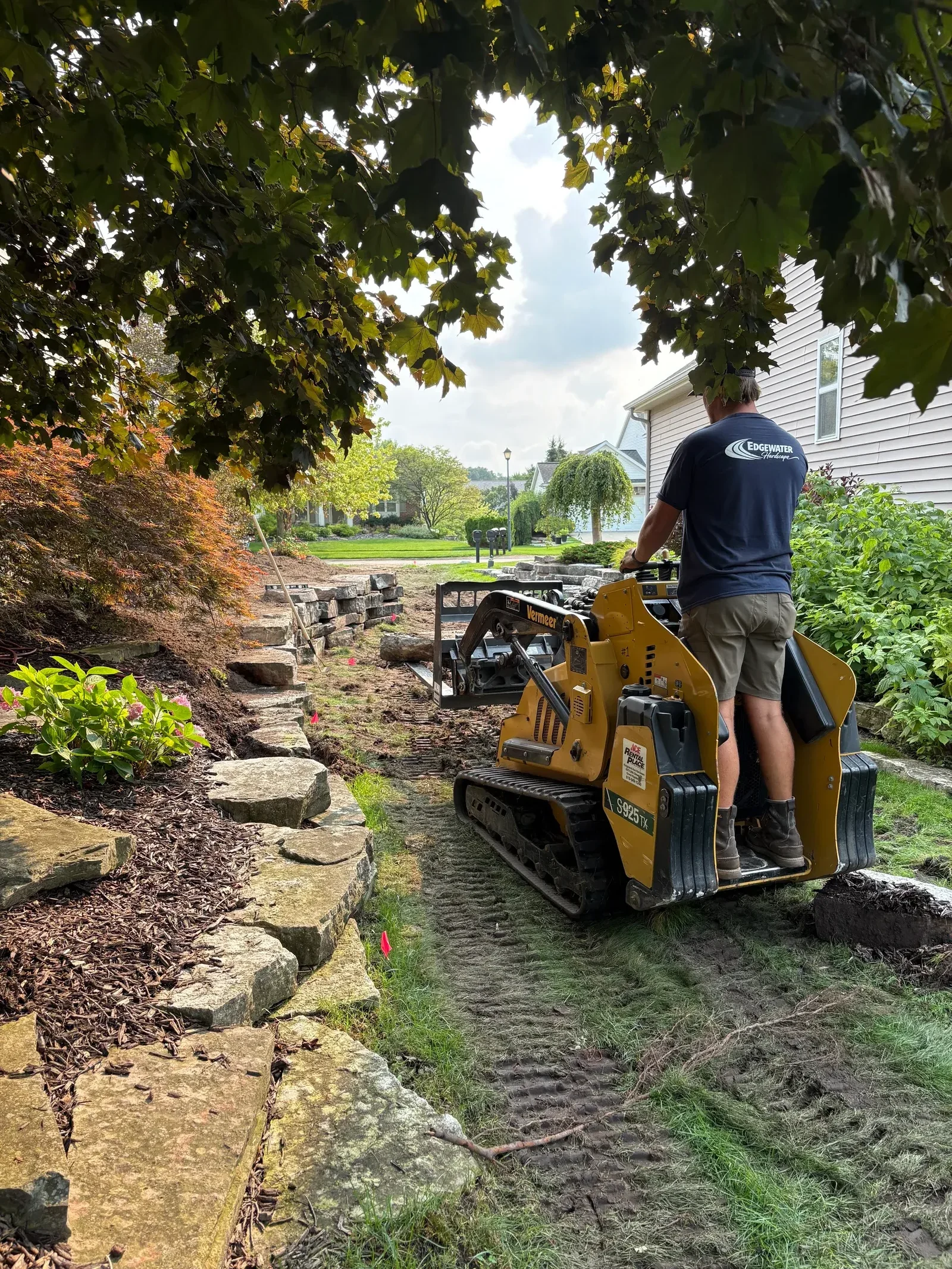 Stone patio installation with masonry work, stepping stones, and landscape integration
